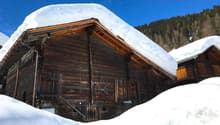 Traditional wooden house, raised ground floor, snowy roof, wooden beams, star decoration