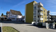 Modern apartment building with yellow facade, brick apartment building, brick sidewalk, brick paving
