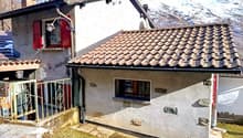 Mountain house, brown roof, white walls, red shutters, small front garden, chimney