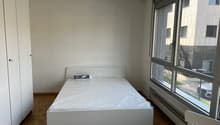 empty bedroom with white bed, white wardrobe, parquet floor, large windows