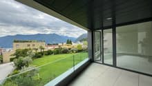 balcony with glass railing, tiled floor, large panoramic window, garden view