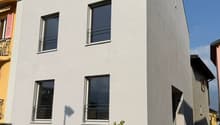White painted house, 3 floors, 4 windows, balcony on second floor