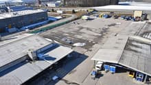 Large industrial complex with warehouses, storage facilities, and parking areas. The area appears to be used for commercial and logistical purposes.