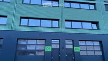 Blue facade, three glass windows per floor, two garage doors, labeled 04 and 05