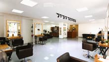 White tiled floor, white walls, modern lighting, chairs, mirrors, tables, shelves, fan, black leather furniture, wooden shelves, track lighting
