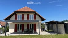 2 story house, red tiled roof, white walls, red shutters, covered balcony, outdoor dining table