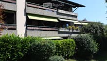 multiple balconies, awnings, windows, garden with hedges