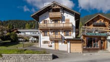 3 story house, white and brown paint, balcony, wooden garage