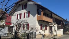 2 story house, white and brown color, red shutters, balcony, fenced yard, red rooftop
