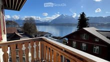 wooden balcony railing, wooden floor, view of a lake and mountains