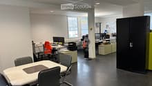 modern office space with desks, chairs, computer monitors, storage cabinets, and a table