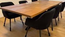 large wooden table, black chairs, wooden floor, large windows