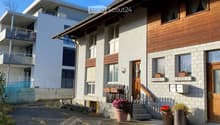 2 story house, white and brown exterior, wooden doors, windows, balcony, potted plants