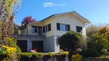 2 story house, white exterior, gray roof, 2 garages, balcony, garden