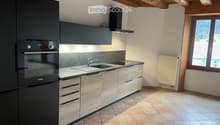 modern kitchen with wooden cabinetry, tiled flooring, black appliances, and a built-in oven, sink, and faucet