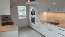 Kitchen. Modern kitchen with white cabinets, marble countertops, induction cooktop, and built-in oven and microwave.