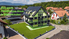 House. Aerial view of a modern house with solar panels, green lawn, and surrounding houses.