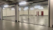Unfurnished Room. Empty warehouse with concrete floor, white walls, and metal beams. There are no visible objects or furniture.