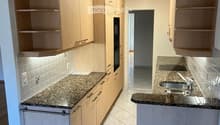 modern kitchen with granite countertops, wooden cabinets, built-in oven, double sink, and dishwasher