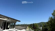Balcony / Terrace. Balcony with a view of a suburban neighborhood, trees, and distant hills under a clear blue sky.