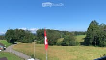 Balcony / Terrace. Balcony overlooking a rural landscape with a flagpole, cows, and a road.