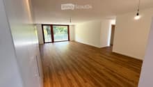large windows, wooden floor, sliding glass door, balcony, white walls, bright lighting