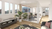 Modern living room with large windows offering a scenic view, featuring a grey sofa, coffee table, side table, bookshelf, and potted plants.