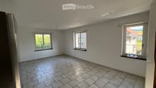 Empty room with tiled floor, three windows, and white walls. No furniture or equipment present.