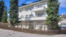 white exterior with windows, balcony on first floor, wooden fence