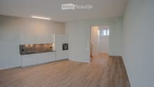 empty kitchen with built-in appliances, white cupboards, wooden floor