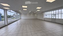 Empty room with tiled floor, large windows, and recessed lighting. No furniture or equipment present.