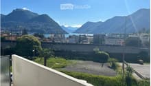 elevated view with balcony railing, mountains, city, lake