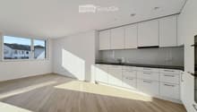 Modern kitchen with white cabinets, light wooden flooring, and a large window offering a view of the street.