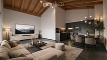 Open-concept living and dining area with a modern aesthetic. Features a large sectional sofa, coffee table, ottoman, dining table with chairs, and a sleek kitchen with dark cabinets and a central island. A large television is mounted on the wall, and the