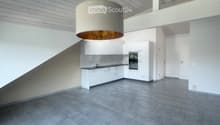 Modern kitchen with white cabinets, a central island, and a pendant light fixture. The space features a sleek, minimalist design with grey tiled flooring and a clean, open layout.