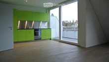 Lime green cupboards, glass door to the balcony, stainless steel oven, wooden floor