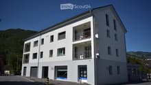 3 story building, white exterior, multiple balconies, garage, windows, door
