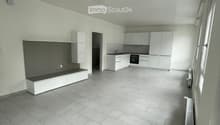 Modern, minimalist kitchen and living area with white cabinets, a built-in bench, and grey tiled flooring.