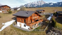Detached house, wooden exterior, two-story, balcony, snowy mountain background