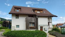 2 story house, white walls, brown roof, wooden balcony, garden, driveway