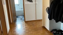 empty room with parquet floor, a closet, a bathroom, a hallway