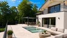 Modern outdoor patio with a swimming pool, white sofa, coffee table, dining area, and potted plants, connected to a house with a balcony and large windows.
