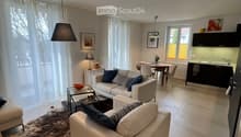 White leather sofas, beige carpet, modern glass coffee table, decorative items, table and chairs, modern kitchen set