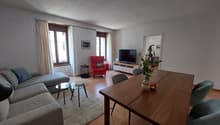 Dining room: table with chairs, living room visible in the background, TV, lamp