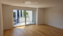 Empty room with wooden flooring and large sliding glass doors leading to a balcony area.