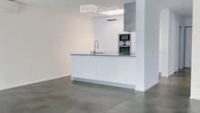 Modern kitchen with white cabinets, stainless steel appliances, and a central island with a sink and faucet.