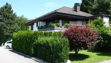Detached house, white exterior, brown roof, balcony, garden, hedge, driveway, car parked