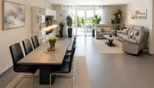 Open-plan living and dining area with modern furniture, pendant lights, and large windows leading to a balcony.