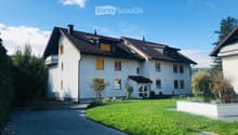 2 story house, white exterior, brown roof, yellow shutters, driveway, well-maintained lawn, plants, trees