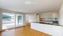 Modern kitchen with white cabinets, a central island, and large sliding glass doors leading to a balcony.